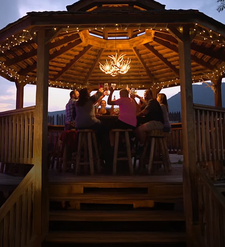 WhiteWater Bar & Grill rustic log cabin venue with American flags, outdoor dining pavilion, and Royal Gorge adventure signage in Canon City, Colorado